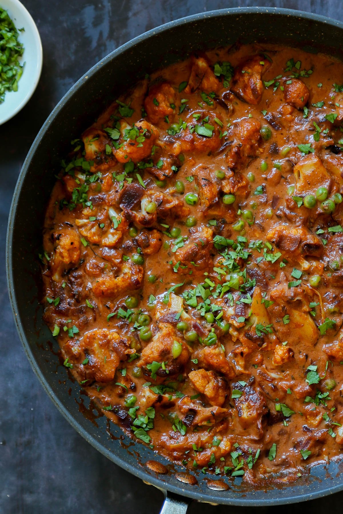 panful of cauliflower pea curry - gobi matar with cilantro on top