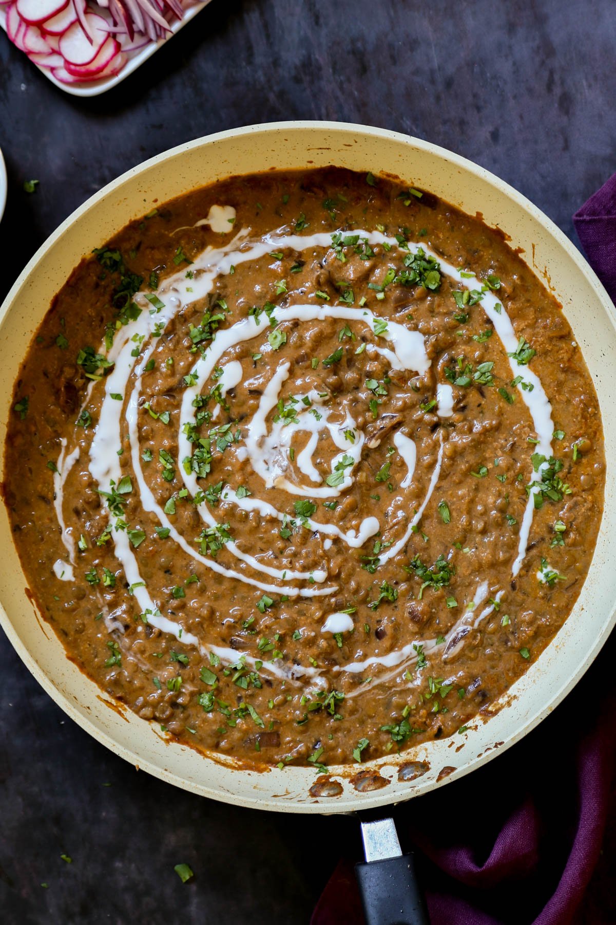 panful of dal do pyaza - Indian lentil curry- with vegan cream and cilantro on top