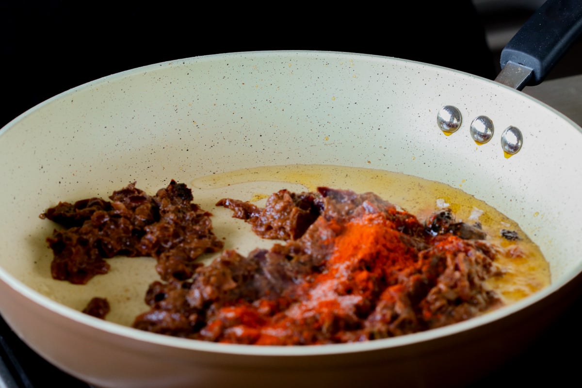 adding ground spices to the do pyaza sauce