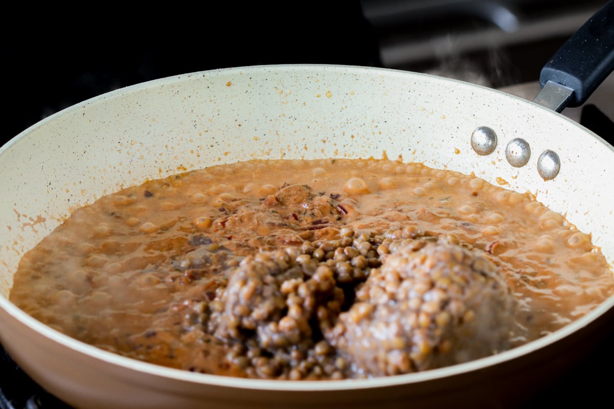 adding lentils to the creamy tomato-yogurt sauce