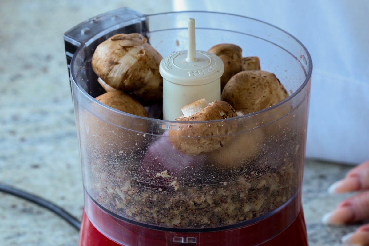 adding mushrooms and lentils to the food processor