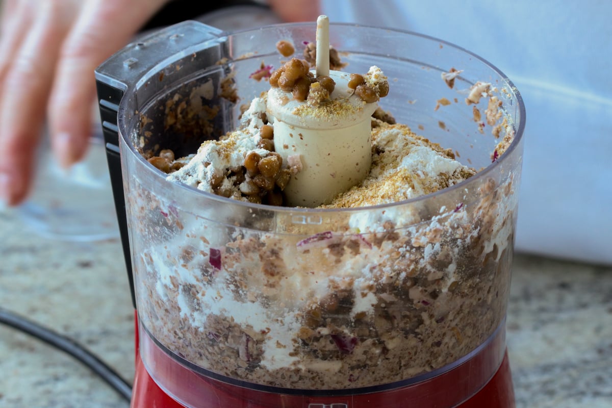 adding binders and seasonings to lentil mixture in the food processor, before running it
