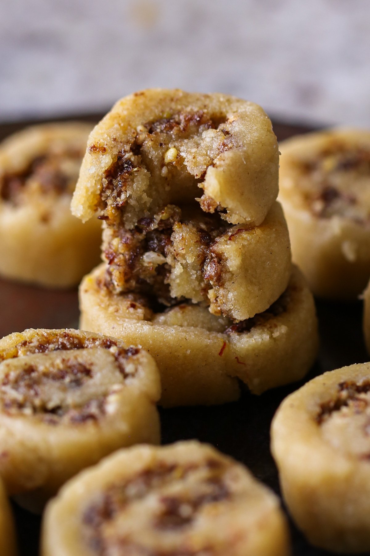 gujiya peda stacked up with bites taken out, so you can see inside