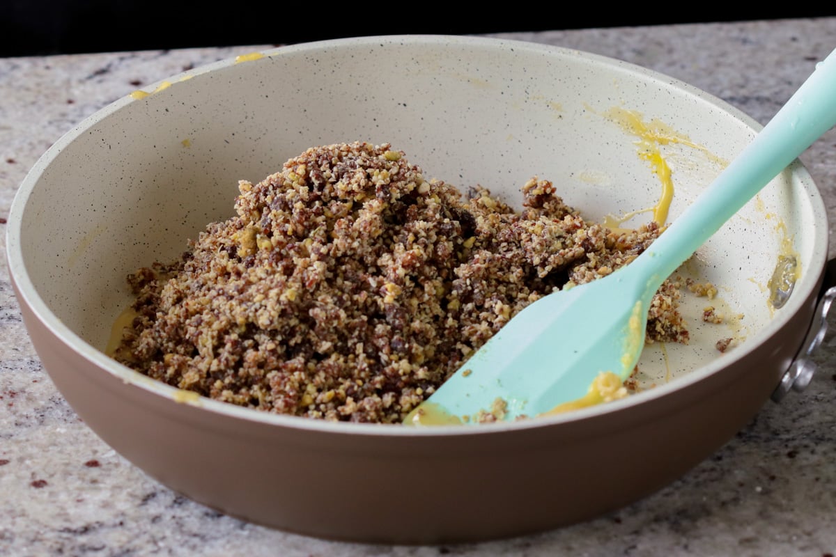 adding gujiya mixture to the custard pan