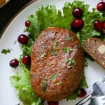 close-up of a chickpea loaf on a plate with lettuce and cranberries