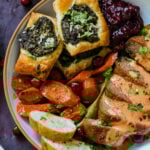spiced glazed carrots on a plate with other Indian-inspired Thanksgiving dishes