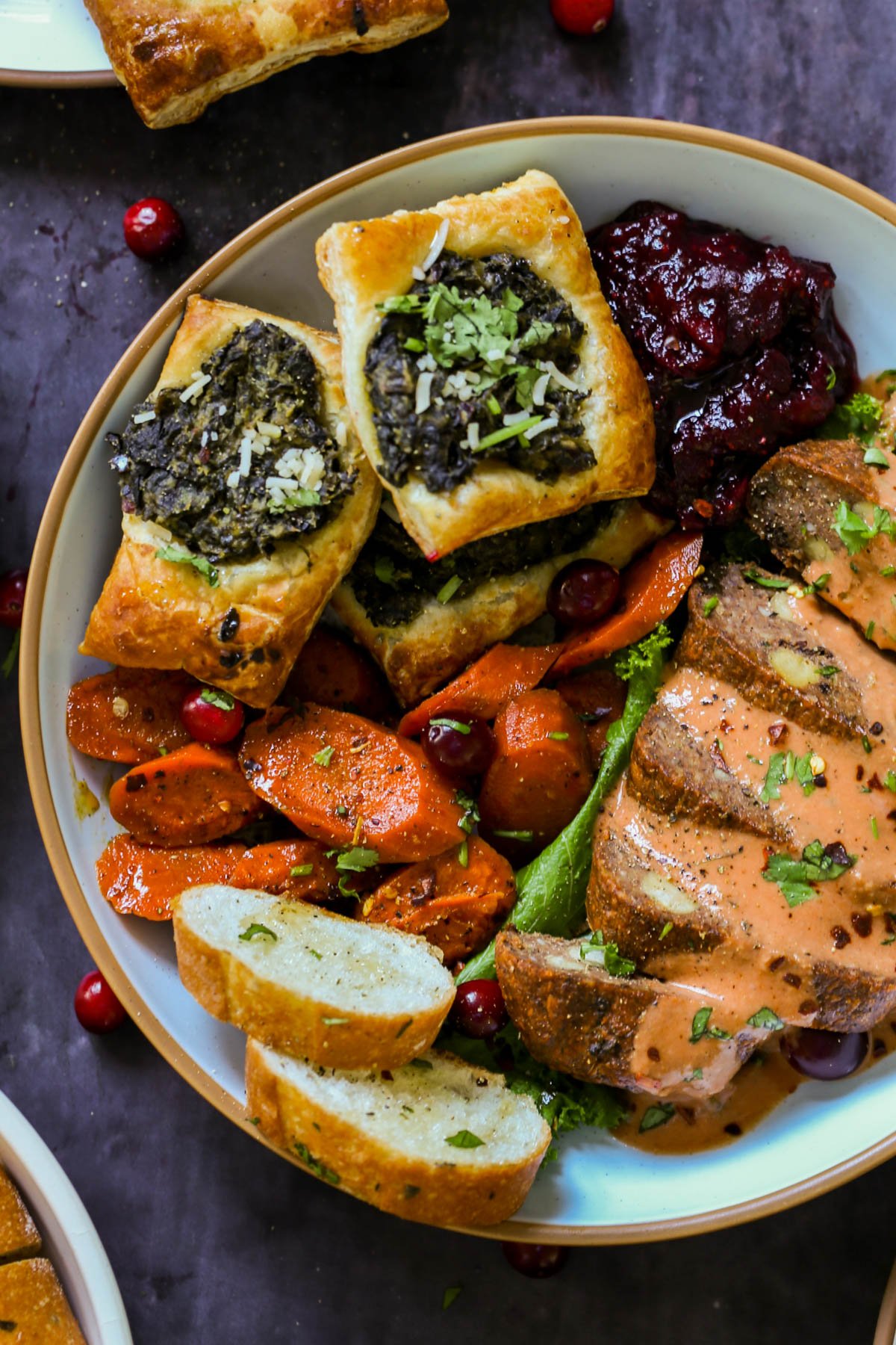 spiced glazed carrots on a plate with other Indian-inspired Thanksgiving dishes
