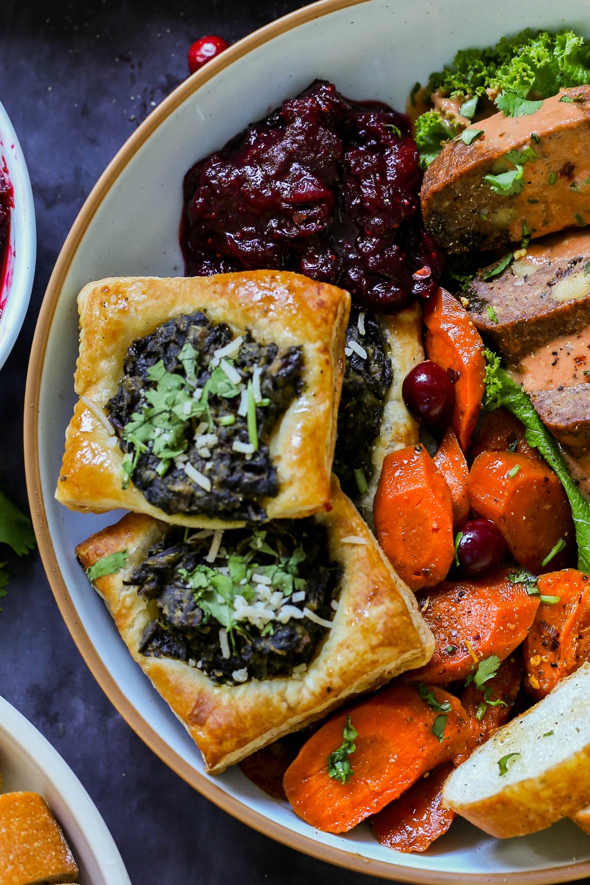 spinach puff pastry on a plate with other Thanksgiving dishes