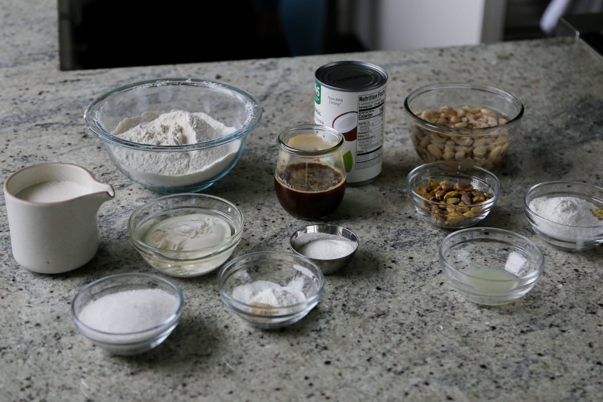 cake and kulfi ingredients in cups and bowls on a kitchen counter