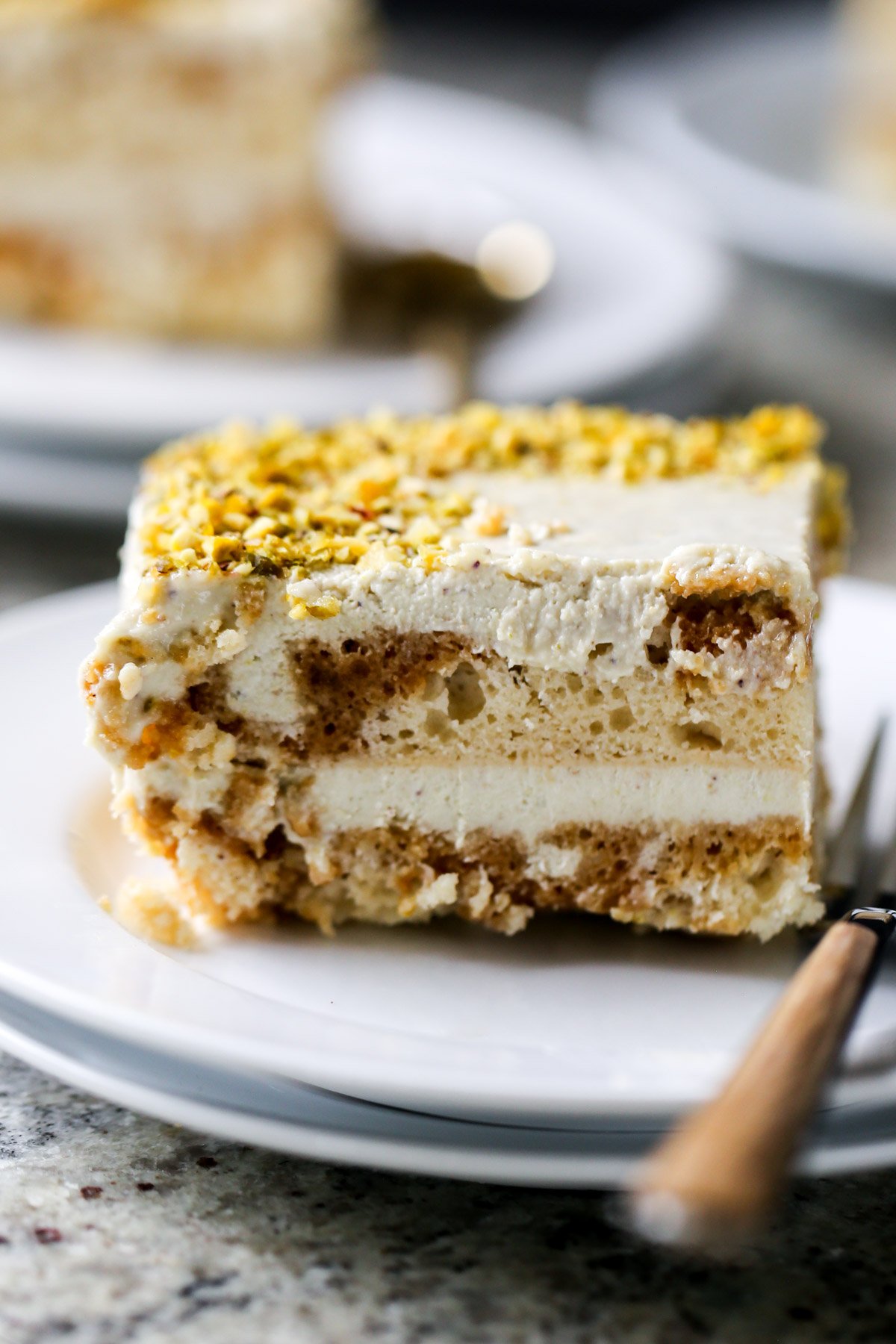 close-up of a slice of Indian tiramisu on a white plate with a fork