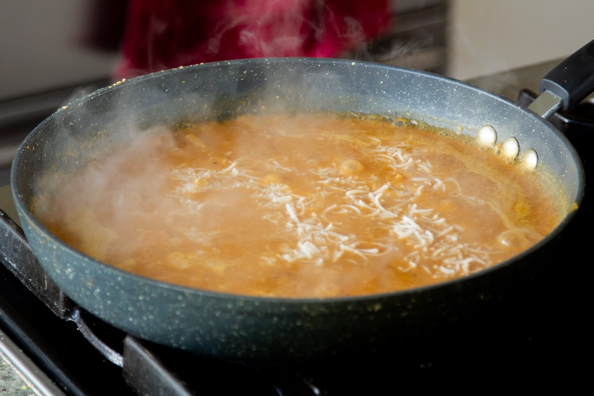 bringing the pumpkin alfredo sauce and pasta to a boil