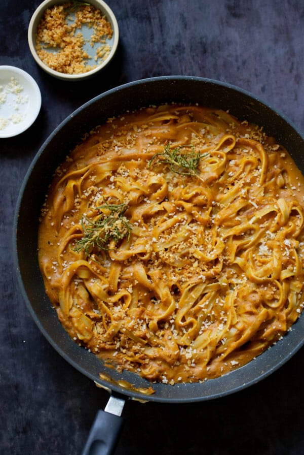 pumpkin alfredo pasta in the pan topped with the rosemary breadcrumbs