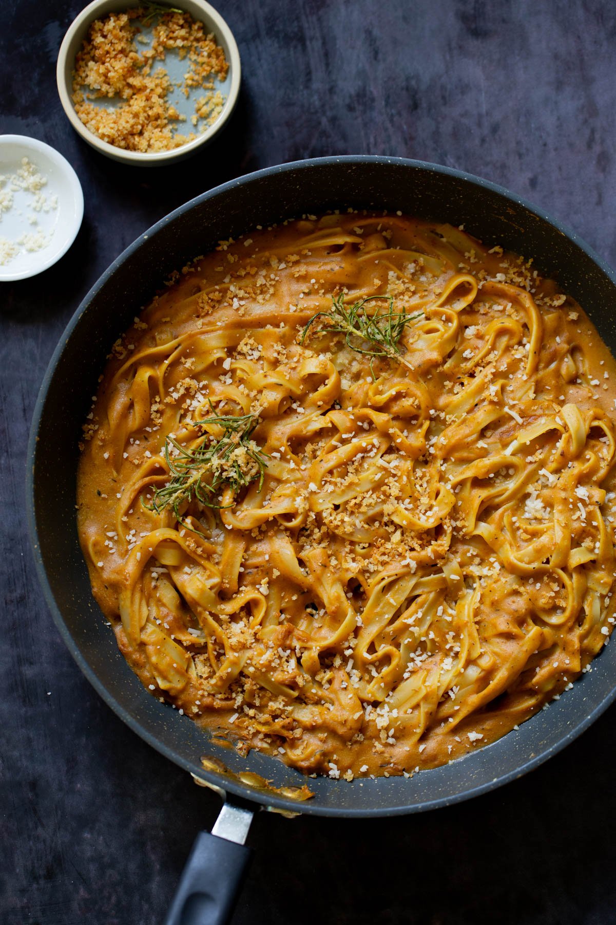 pumpkin alfredo pasta in the pan topped with the rosemary breadcrumbs