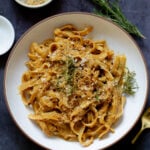 pumpkin alfredo pasta in a bowl topped with the rosemary breadcrumbs