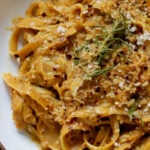 close-up of pumpkin alfredo pasta in a bowl topped with the rosemary breadcrumbs