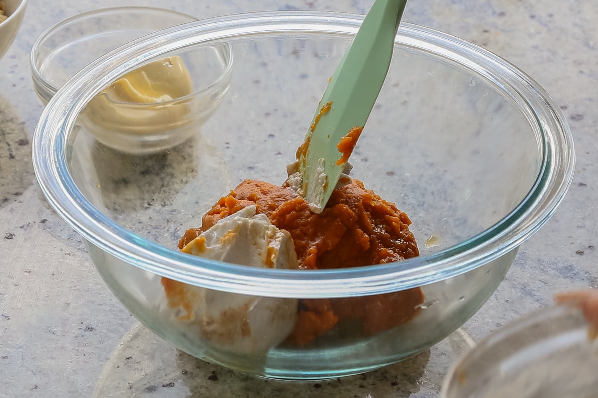 adding the pumpkin and coconut cream to a bowl