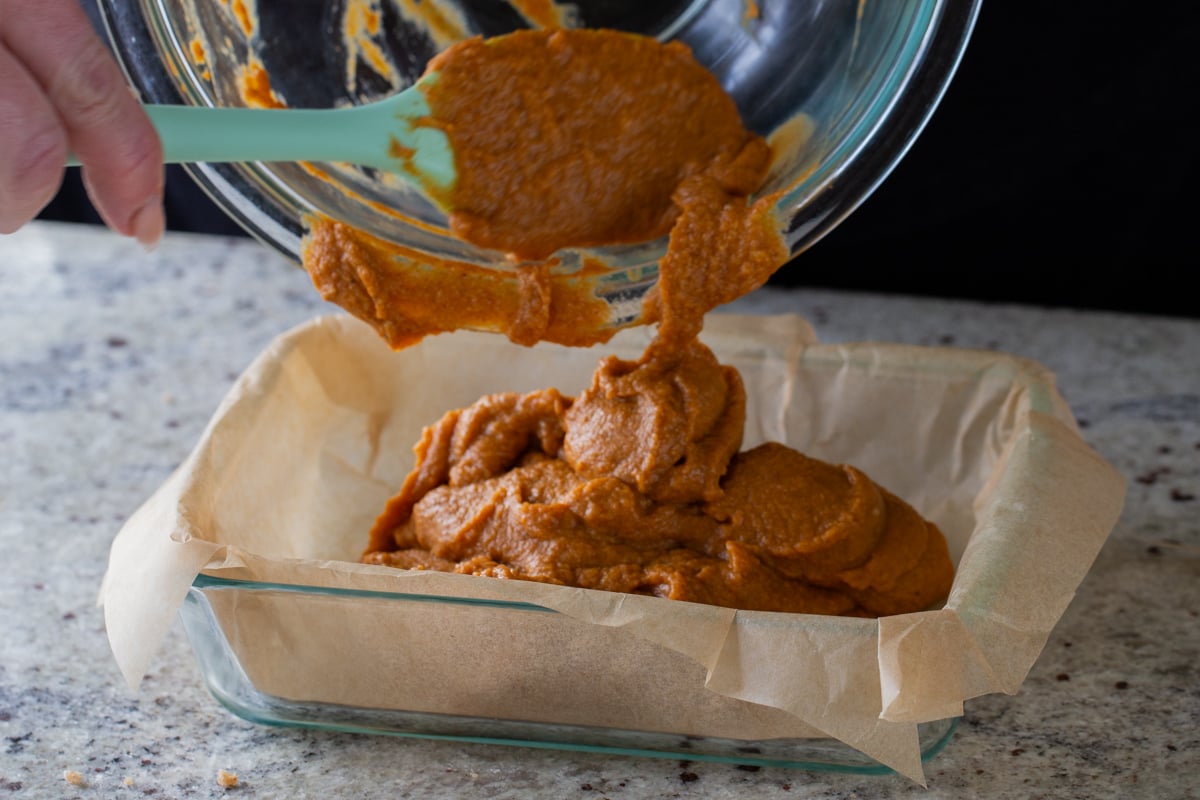 transferring pumpkin crisp filling to the lined baking pan