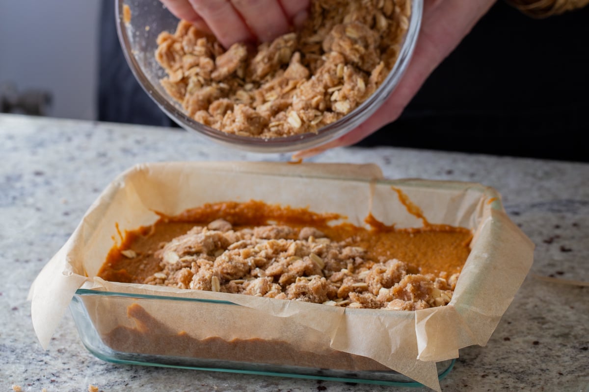 adding the crumb topping to the baking pan