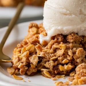 close-up of slice of pumpkin crisp on a white plate with ice cream on top
