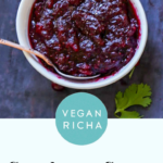 bowl of cranberry chutney as part of a Thanksgiving spread, text overlay