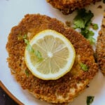 tofu schnitzel on a plate with salad and lemon
