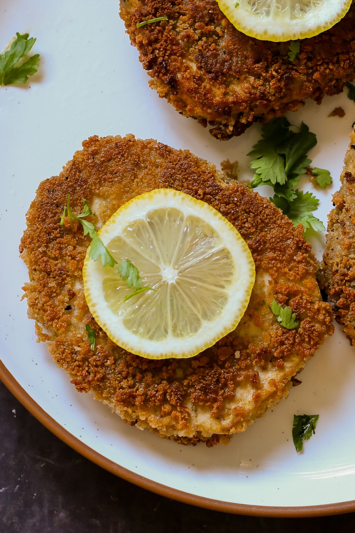 tofu schnitzel on a plate with salad and lemon