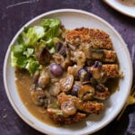tofu schnitzel on a plate with salad and mushroom gravy