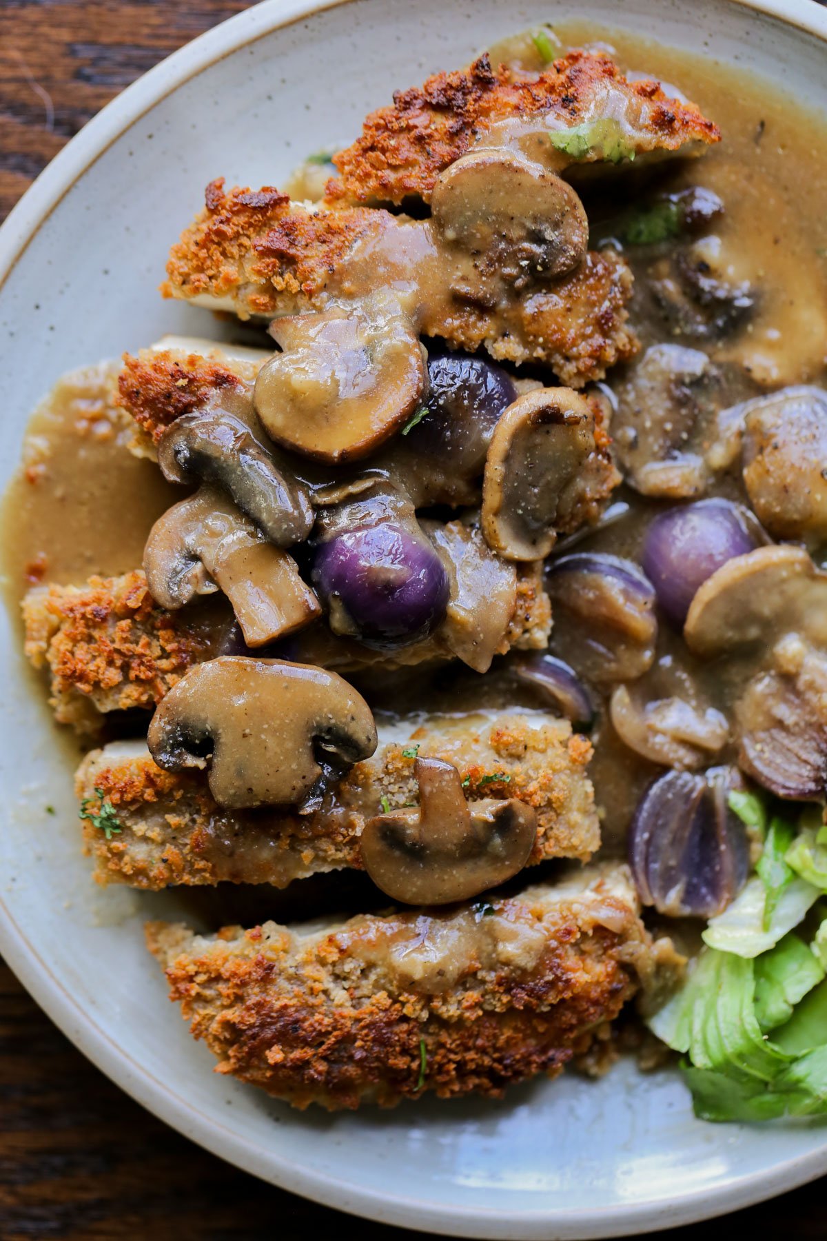 close-up of tofu schnitzel on a plate with salad and mushroom gravy