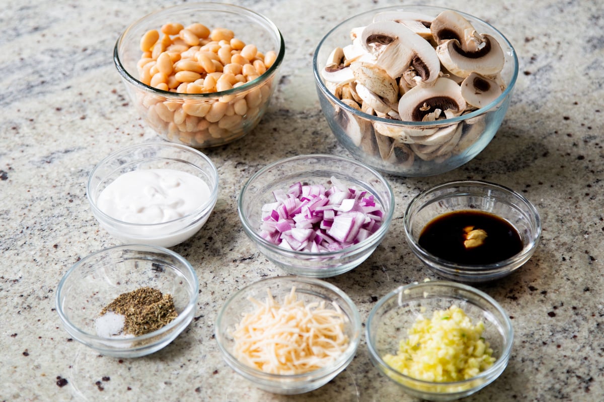 beans, mushrooms, and other vegan stroganoff ingredients in bowls on the counter