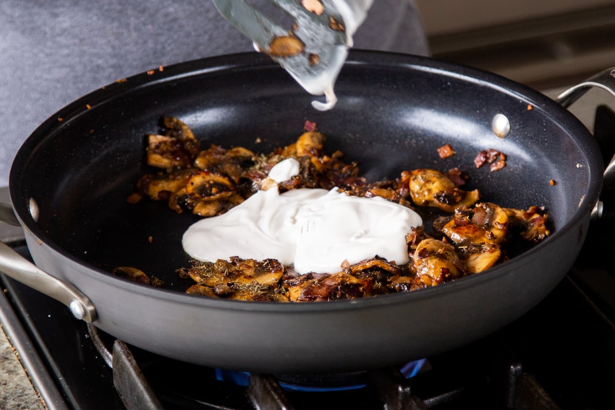 adding vegan sour cream to the cooked mushrooms
