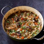 angled shot of mushroom noodle soup in the pan