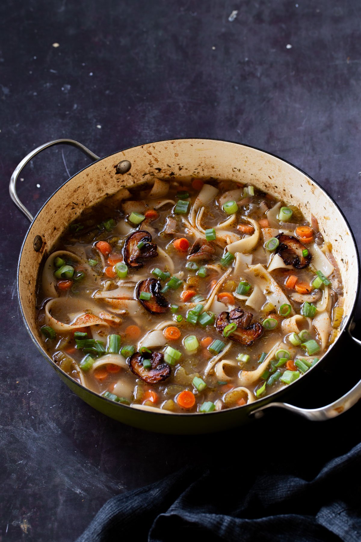 angled shot of mushroom noodle soup in the pan
