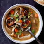 bowl of mushroom noodle soup on a slate table