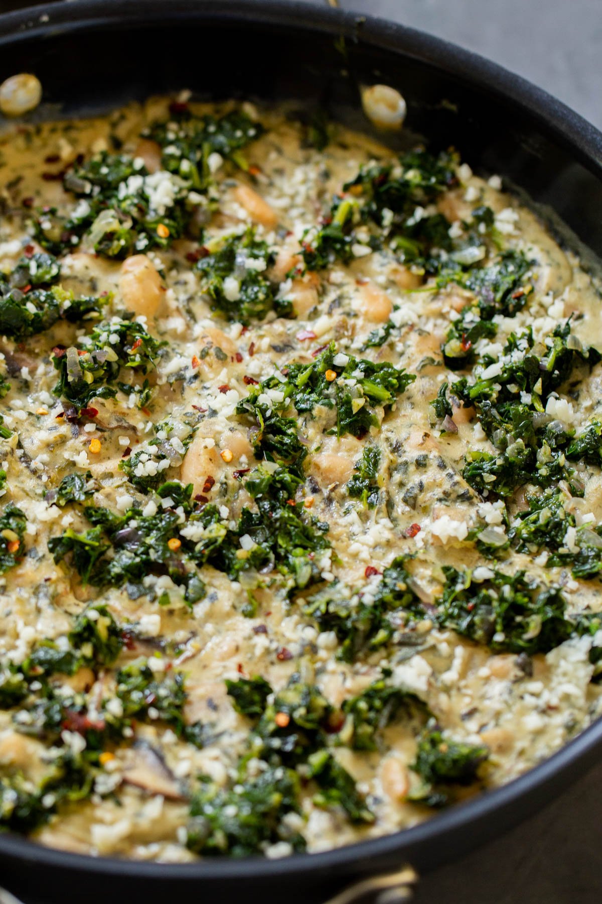 close-up of vegan white bean mushroom alfredo in the pan with spinach