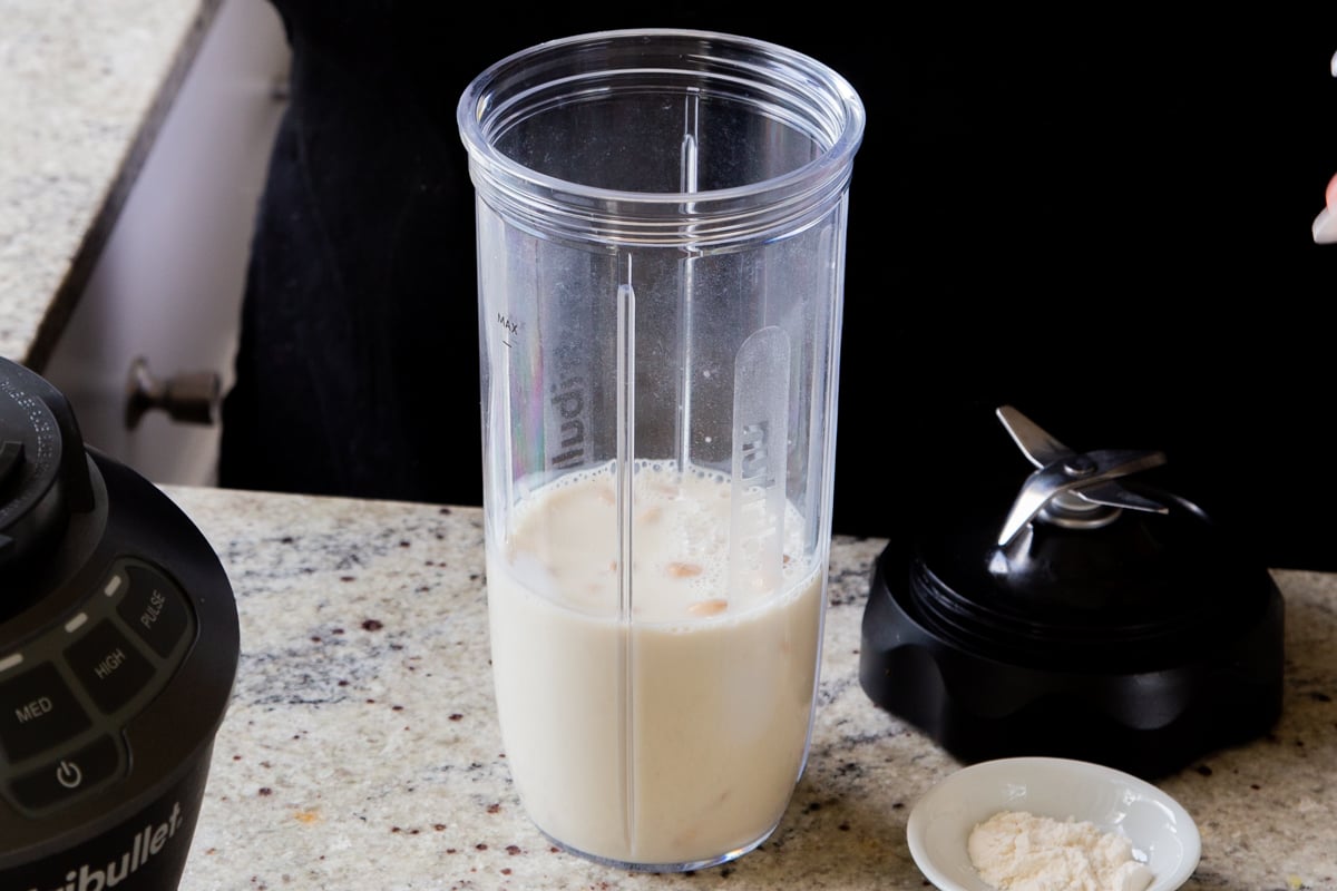 adding non-dairy milk to the blender with the cashews