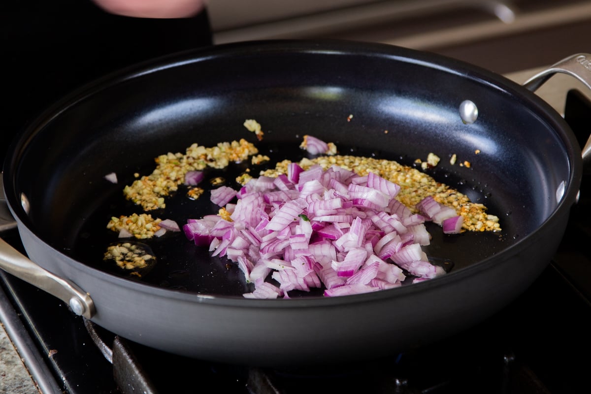adding onions to the sautéed garlic