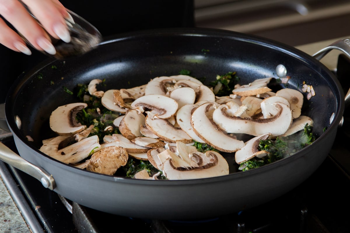 adding mushrooms to the onion-spinach mixture