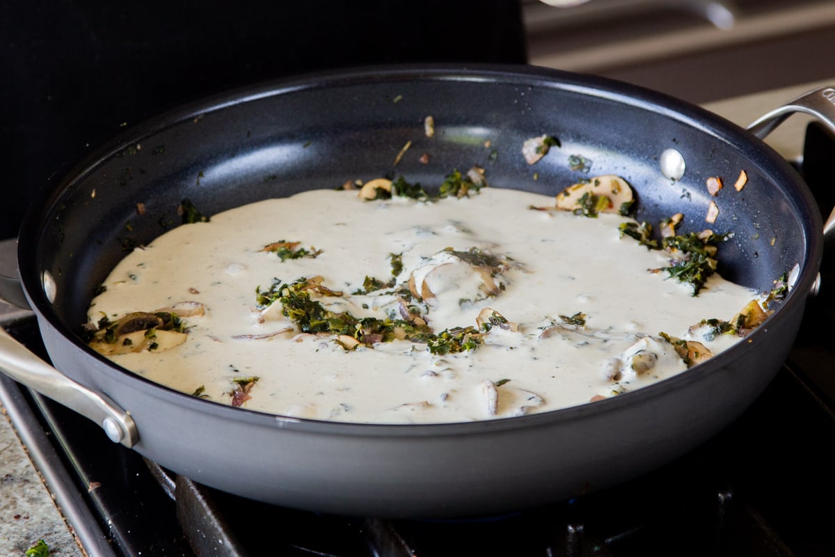 adding blender alfredo sauce to the cooked mushroom mixture