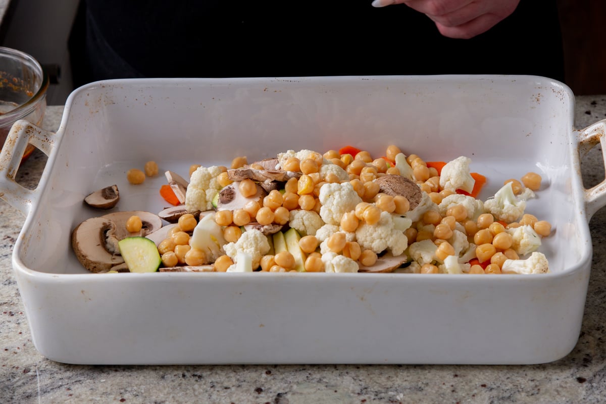 adding chickpeas to the pan of veggies