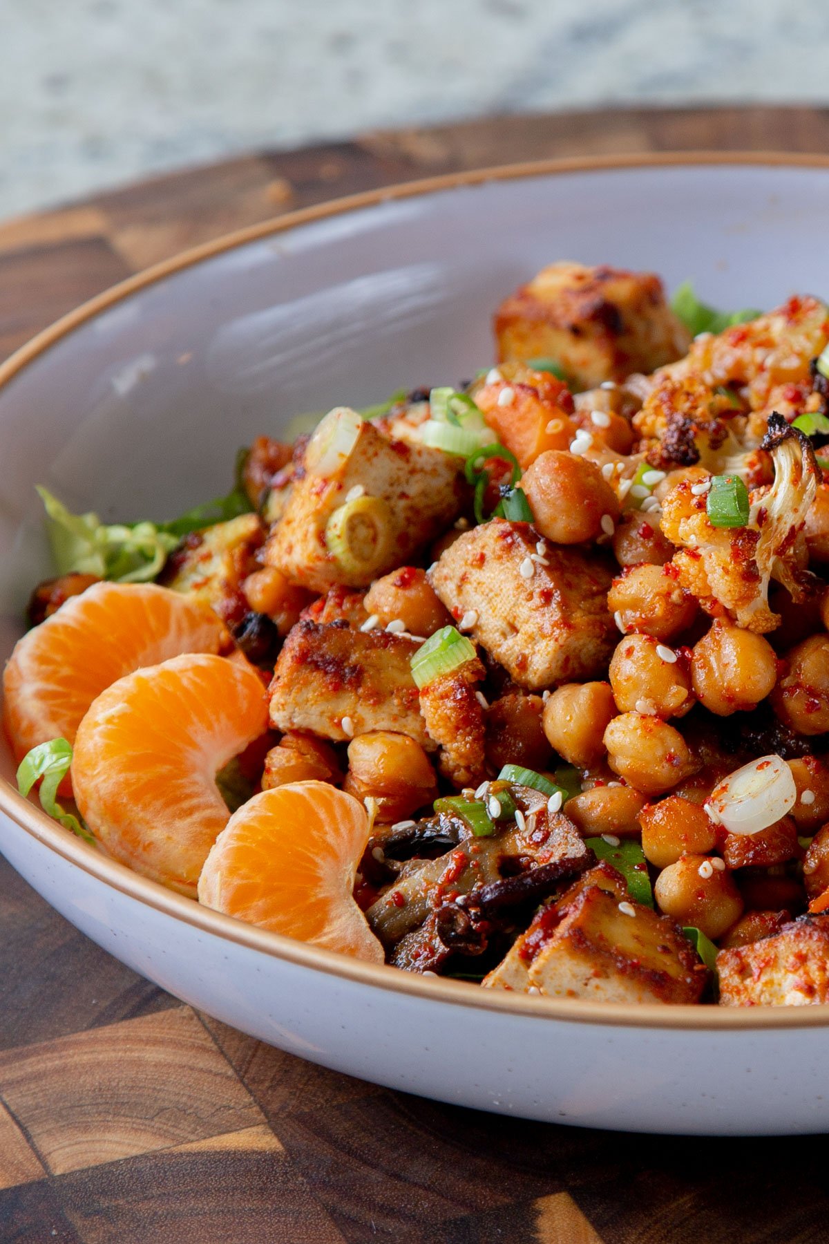 gochujang tofu and veggies in bowl over lettuce