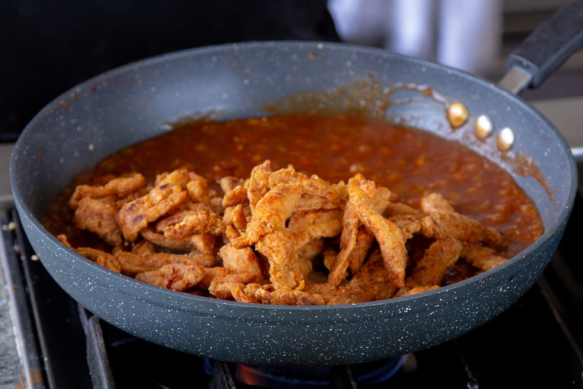 adding soy curls to the pan of sauce