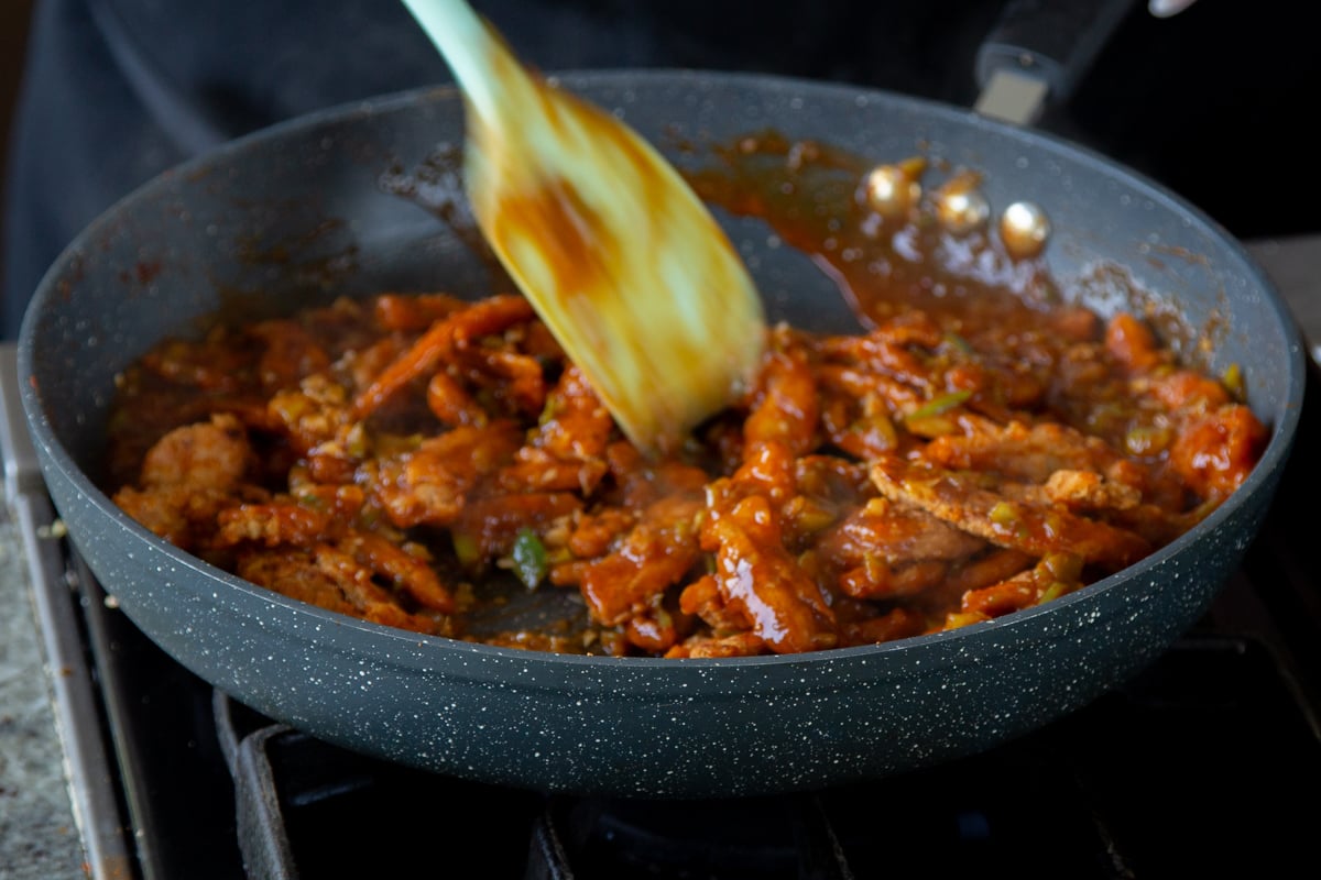 mixing soy curls into the sauce