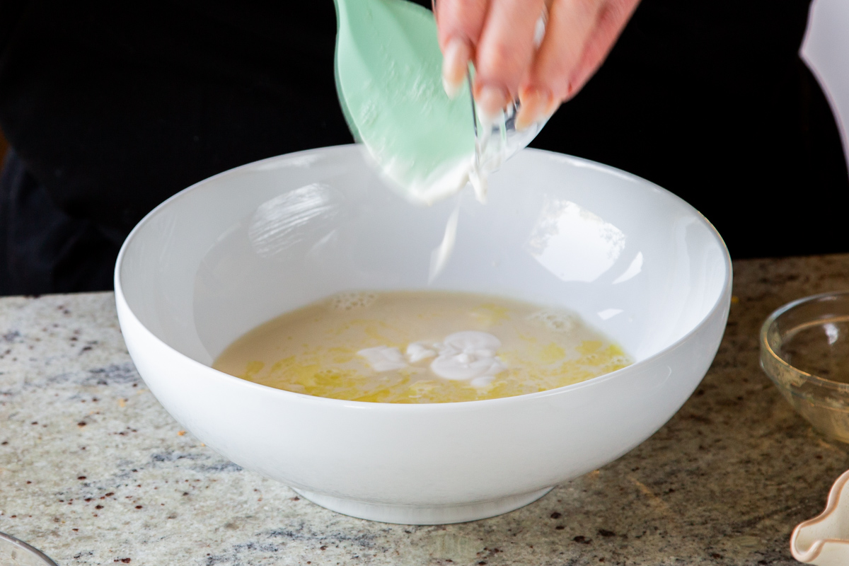 adding non-dairy yogurt to the wet ingredients in a mixing bowl