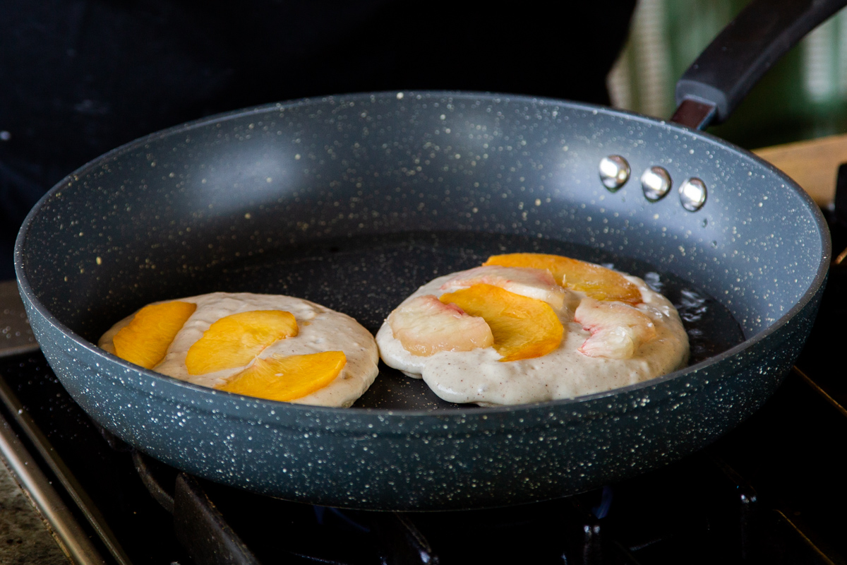 covering the pancakes in peaches