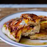 a plate of peach upside-down pancakes with a piece cut out, so you can see the fluffy inside