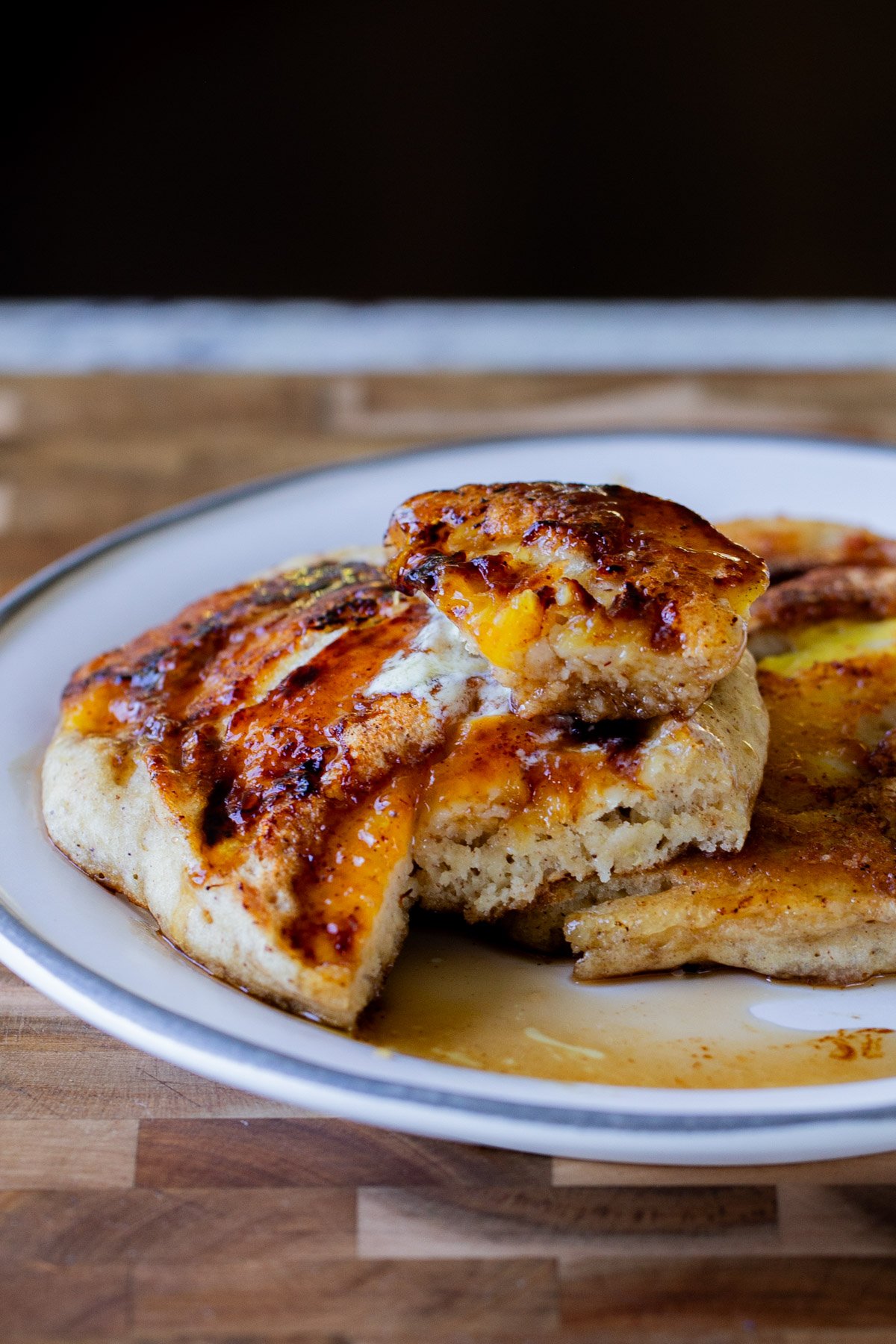 a plate of peach upside-down pancakes with a piece cut out, so you can see the fluffy inside