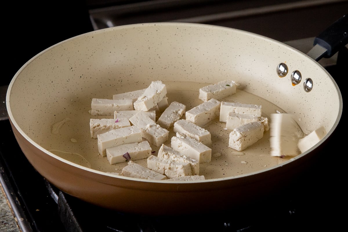 adding tofu to the skillet