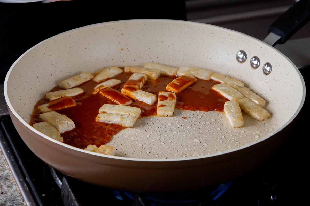adding gochujang sauce mixture to the crisped up tofu