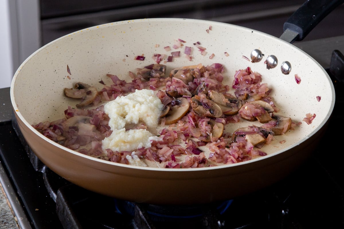 adding ginger garlic paste to the onion-mushroom mixture