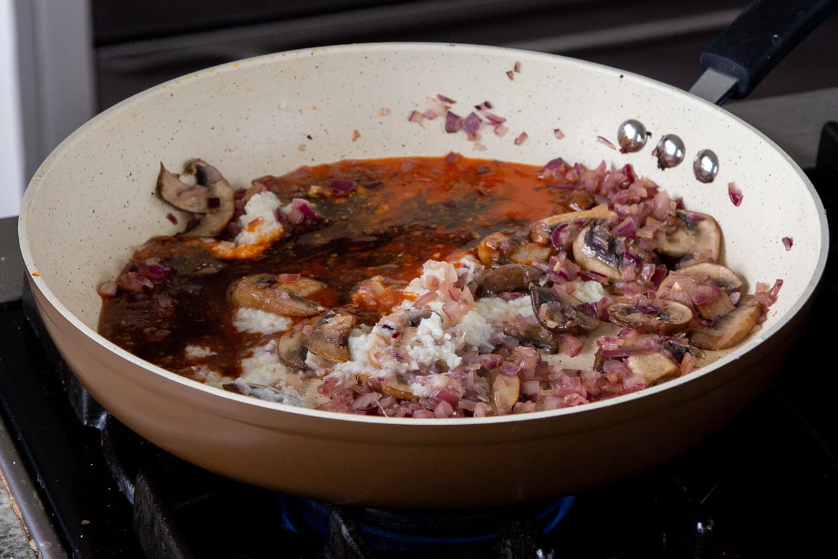 adding sauces to the pan with the ginger garlic paste